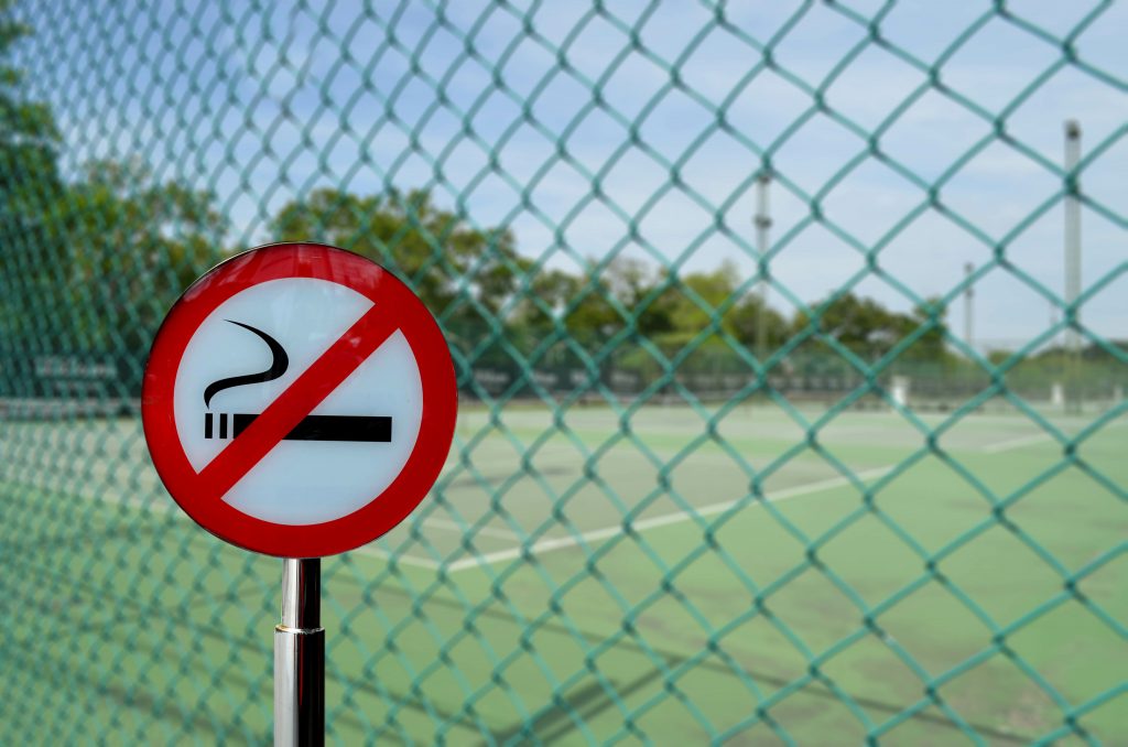 Symbol nefajčiť pred futbalovým ihriskom, zdravý koncept